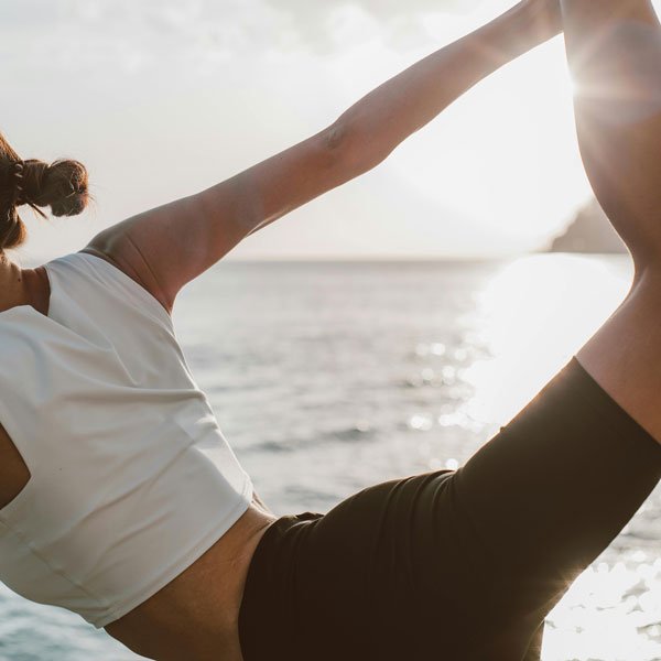 Image of woman stretching in the sunlight